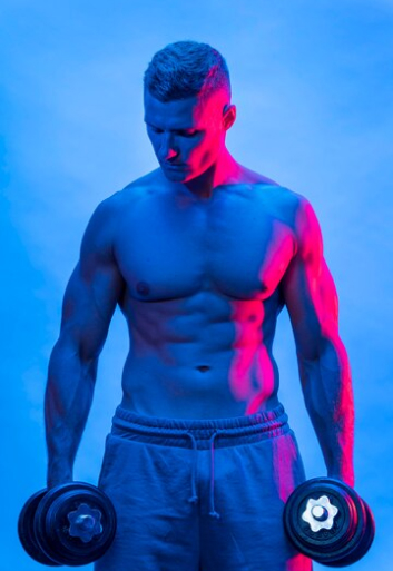 Спортивный парень держит в руках гантели